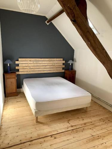 - une chambre avec un lit blanc et du parquet dans l'établissement Maison Normande T'cheu Clémence, à Magneville