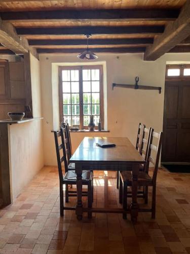 une salle à manger avec une table et des chaises en bois dans l'établissement Maison Normande T'cheu Clémence, à Magneville