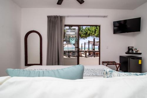 a bedroom with two beds and a balcony at HAU Holbox, Oceanfront Boutique Hotel in Holbox Island