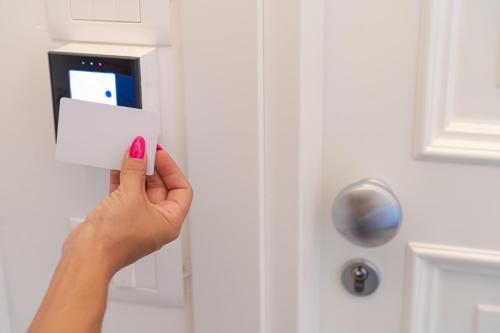 a woman holding a piece of paper in front of a white door at Suite The Mana Vista Mare in Centro - Casamicciola Terme in Ischia