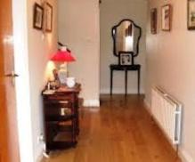 a hallway with a table and a lamp and a mirror at Dun Roamin in Galway