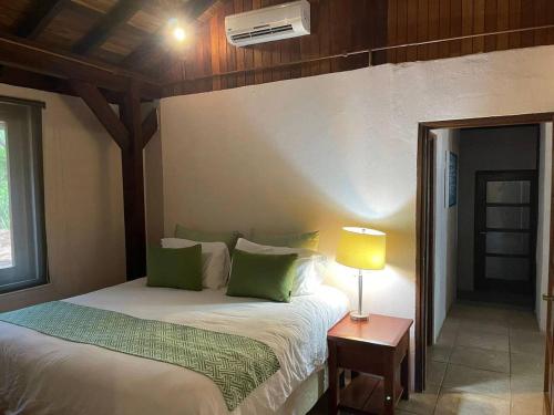 a bedroom with a bed and a table with a lamp at Villa Los Tamarindos in San Juan del Sur