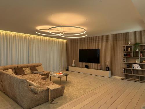 a living room with a couch and a flat screen tv at Kempinski Villa 100m from Beach in Savudrija