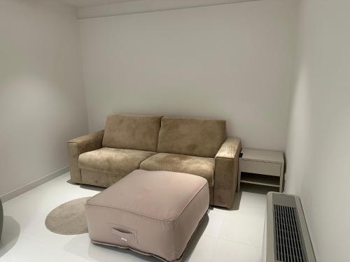 a living room with a couch and a ottoman at Kempinski Villa 100m from Beach in Savudrija