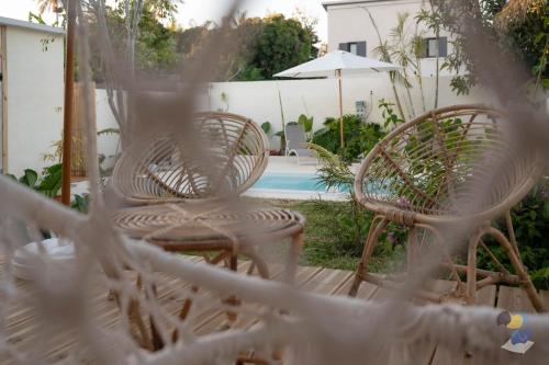two chairs and an umbrella next to a pool at L'oasis 3 étoiles - Lodge 1 - DODOTERLA in Le Tampon