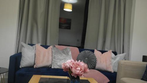 a living room with a blue couch with pink and grey pillows at Newly Renovated 3 Bedroom House, 6 beds with 2 showers, near University Town Centre in Lancaster