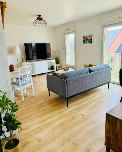 un salon avec un canapé et une table dans l'établissement Grand Duplex à 400m de la plage, à Saint-Aubin-sur-Mer
