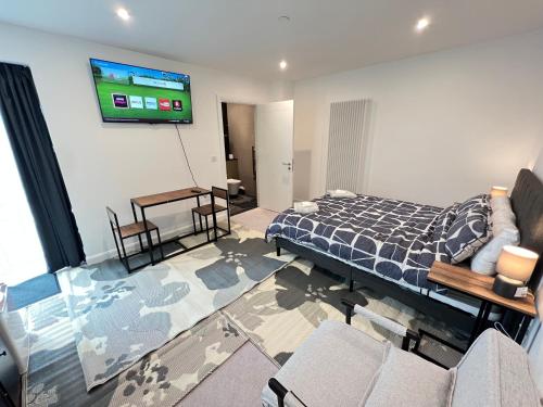 a bedroom with a bed and a tv on the wall at Lux New Studio Excel London in London