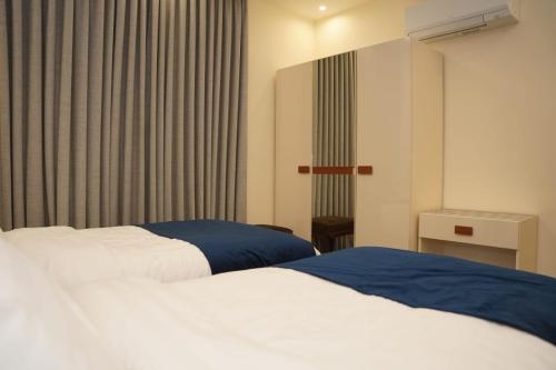 a hotel room with two beds and a window at أوتار ذهب للشقق الفندقية الفاخرة in Ma‘ān
