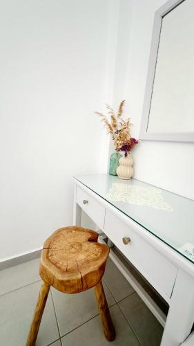 a white desk with a stool and a mirror at Kirki Rooms by the sea in Parikia