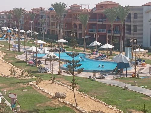 a pool at a resort with people swimming in it at Porto Luxury Rentz in Marsa Matruh