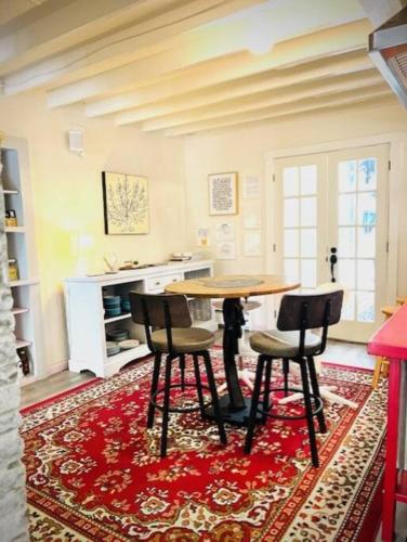a kitchen with a table and chairs on a red rug at Catskill Cabin, Cool Apartment, 2nd Floor in Shandaken