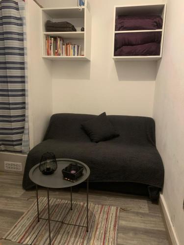 un salon avec un canapé et une table dans l'établissement Studio Paris Charonne, à Chennevières-sur-Marne