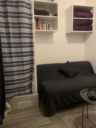 une chambre avec un lit et une étagère dans l'établissement Studio Paris Charonne, à Chennevières-sur-Marne
