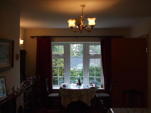 高威的住宿－敦羅安名酒店，一间窗户前带桌子的用餐室