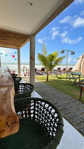 a patio with a table and chairs and the beach at Rudá Boutique Hotel Porto de Galinhas in Porto De Galinhas
