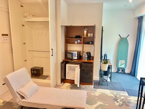 a living room with a chair and a desk with a surfboard at Lux New Studio Excel London in London