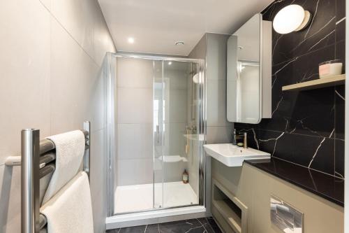 a bathroom with a shower and a sink at Lux New Studio Excel London in London