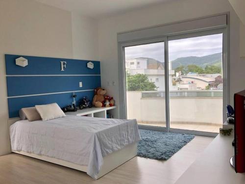 una camera da letto con un letto e una grande finestra di Lagoa da Conceição Residence a Florianópolis