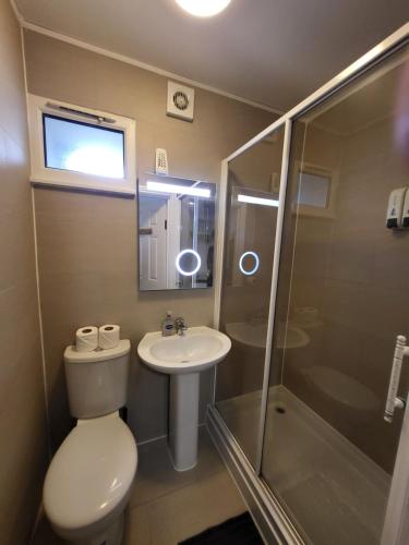 a bathroom with a toilet and a sink and a shower at Abbey Point Hotel in London