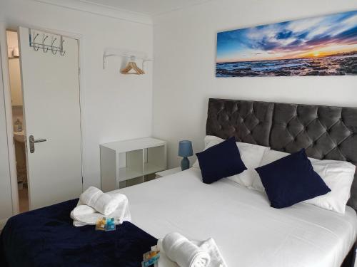 a bedroom with a white bed with blue pillows at Prestige in Cambridge