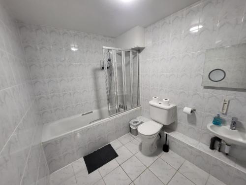 a white bathroom with a toilet and a sink at Abbey Point Hotel in London