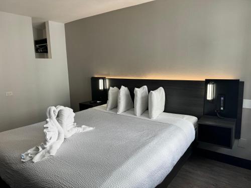 a bedroom with a large bed with white sheets and pillows at Motel 6 Hollywood in Los Angeles
