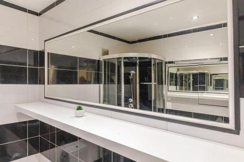 La salle de bains est pourvue d'un comptoir blanc et de miroirs. dans l'établissement Suquet Beach Center - 100m from beach & 10min Palace, à Cannes