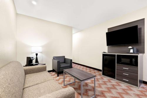 a living room with a couch and a flat screen tv at Best Western Plus Irvine Spectrum Hotel in Lake Forest
