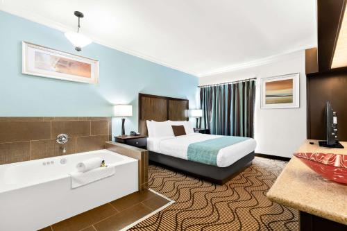 a hotel room with a bed and a bath tub at Best Western Plus Irvine Spectrum Hotel in Lake Forest