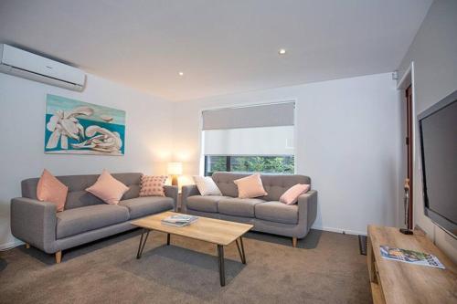 a living room with two couches and a table at Home from home Central City Apartment in Christchurch
