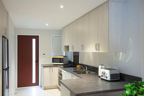 a kitchen with white cabinets and a counter top at Home from home Central City Apartment in Christchurch
