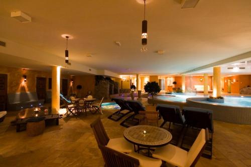 a lobby with tables and chairs and a swimming pool at Grand Rose SPA Hotel in Kuressaare