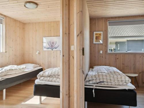 two beds in a room with wooden walls at Luxury Retreat Nr Lyngby - By Traum Ferienwohnungen in Nørre Lyngby