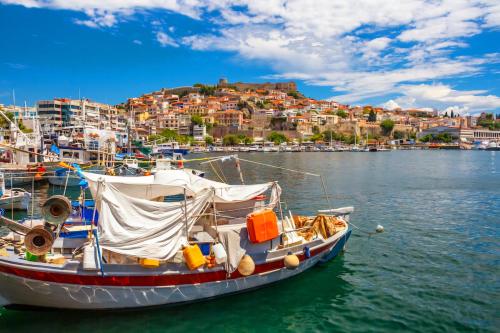 a boat in the water with a city in the background at SUN and Sea HOUSE Kavala ammolofoi αμμόλοφοι in Eleftheres