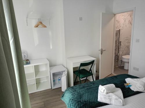 a small bedroom with a bed and a green chair at Prestige in Cambridge