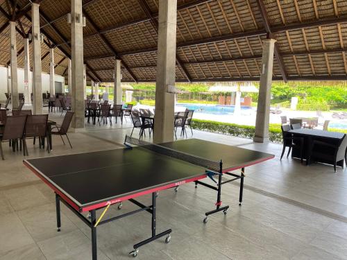 a ping pong table in a pavilion with tables and chairs at Villa Paraiso do Mar in Jacó