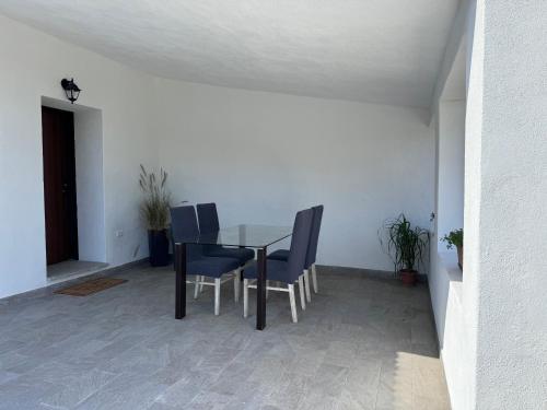 a dining room table and chairs in a room at Appartamento Budoni in San Lorenzo