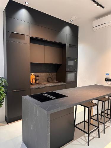 - une cuisine avec un grand îlot de cuisine avec des tabourets de bar dans l'établissement Capsule ciné glisse - cinéma - spa balnéo - garage, à Roubaix