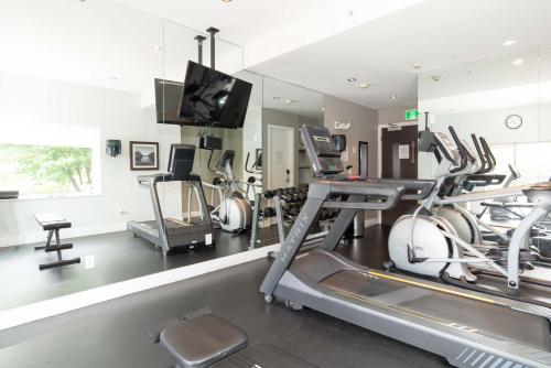 a gym with cardio machines and a flat screen tv at Sandman Hotel Abbotsford Airport in Abbotsford
