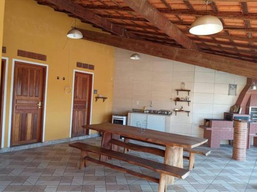 eine Küche mit einem Holztisch in einem Zimmer in der Unterkunft Chalé Vitória 1- Rancho dos 7 in Arapeí
