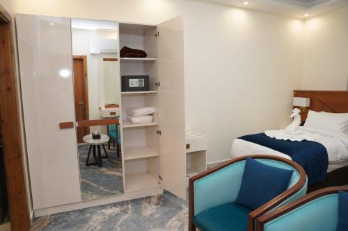 a bedroom with a mirror and a bed and a chair at أوتار ذهب للشقق الفندقية الفاخرة in Ma‘ān