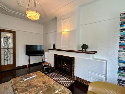 a living room with a fireplace and a television at Art Deco Boutique Bespoke Brilliance & Beach&Park in Melbourne