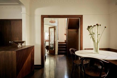 a room with a table with a vase of flowers on it at Art Deco Boutique Bespoke Brilliance & Beach&Park in Melbourne