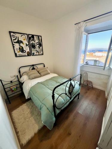 a bedroom with a bed and a large window at Casa Bisa in Ribeira