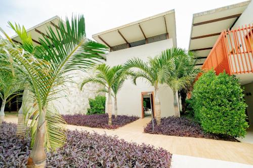 a courtyard with palm trees in front of a building at île de Pipa - Ma Plage Hotel in Pipa