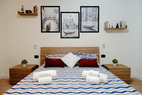 a bedroom with a large bed with pictures on the wall at MJ Venice Guest House in Marghera
