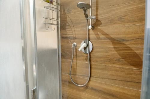 a shower with a shower head on a wooden wall at MJ Venice Guest House in Marghera