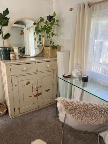 a dresser with a mirror and a glass table at The Van in Porchfield