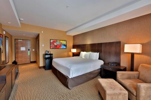 a hotel room with a bed and a couch at Edmonton Hotel & Convention Center Edmonton in Edmonton